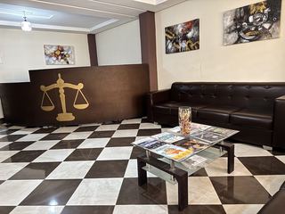 Le comptoir d'accueil, un canapé et la table basse où sont posées les revues