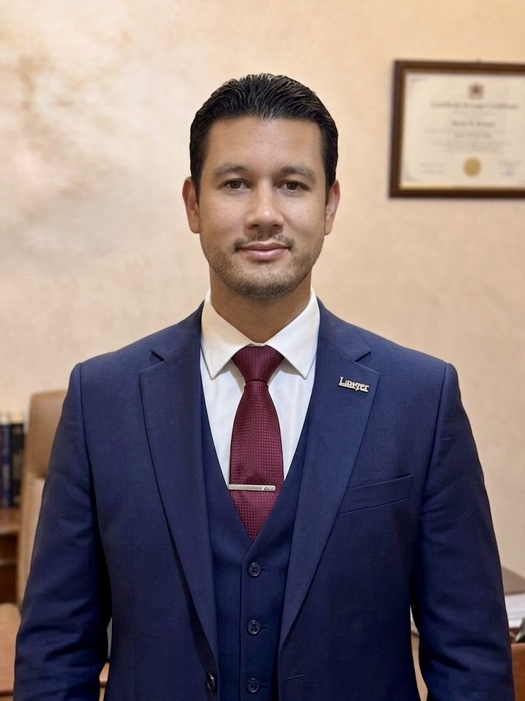 Maître Mourad Essbissi, avocat au Barreau d'Oujda, debout dans son cabinet, en costume sombre